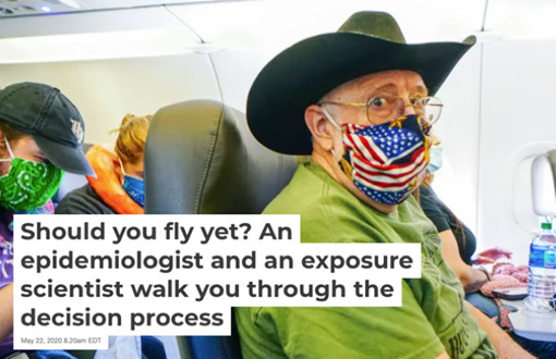 Photo of a man in airplane with cowboy hat and mask on