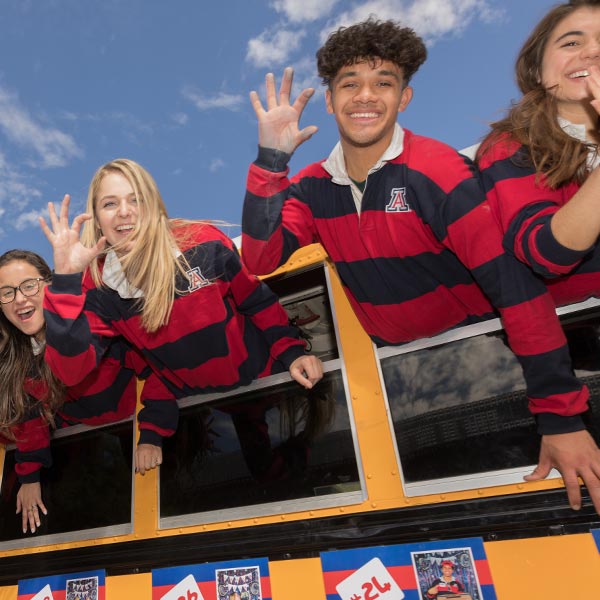 Students waving from a bus